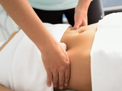 Hands massaging female abdomen.Therapist applying pressure on be